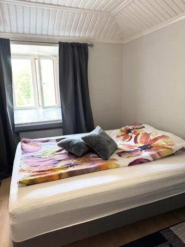 a bed with a colorful blanket on it in a bedroom at Rautatien ullakkohuoneisto in Karkkila