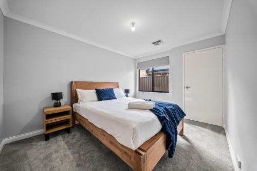 a bedroom with a large bed with a wooden headboard at Nest in The Vines in The Vines