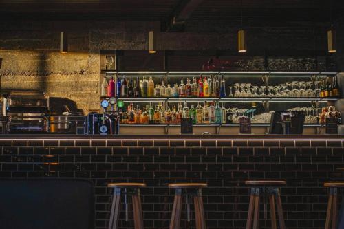 a bar with three bar stools in a room at Black Beach Suites in Vík