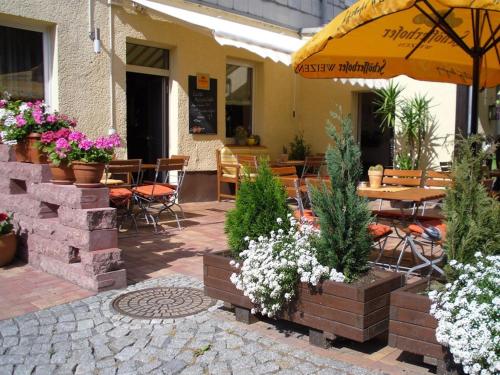 an outdoor patio with tables and chairs and flowers at Hotel & Gasthaus Forelle in Thale