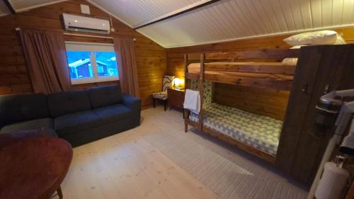 a room with a couch and a bed in a cabin at Ugglan' in Undenäs
