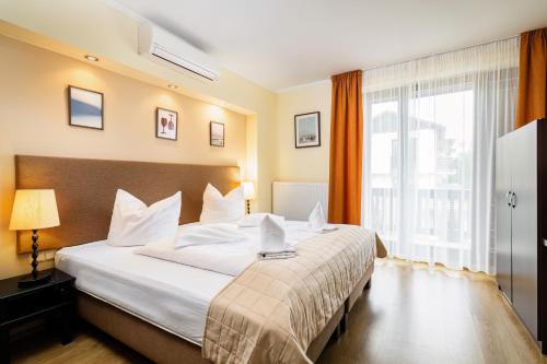 a hotel room with a large bed and a large window at Fürjes Villa Panzió in Balatonfüred