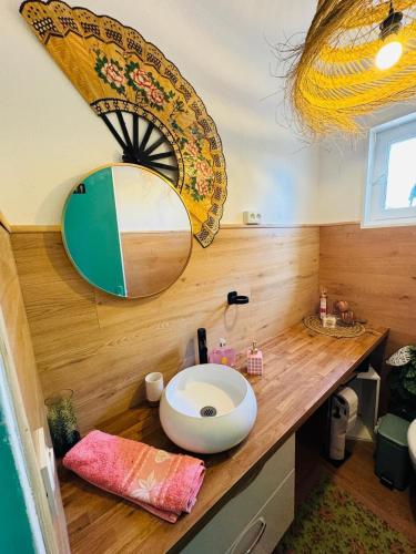 a bathroom with a sink and a mirror on a counter at Maison Donarosa Charmant in Vieille-Brioude