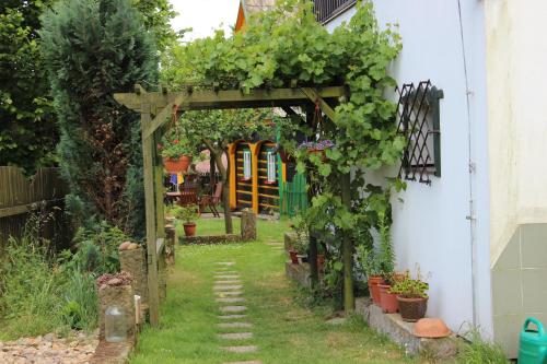 a garden with a wooden arch with plants on it at Penzion Pod Rozhlednou in Janov