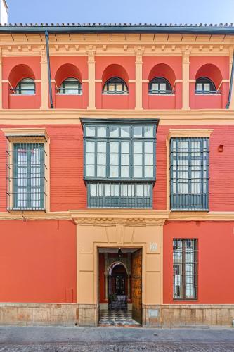 an orange building with windows and a door at Casa Palacio Guiomar by SHS in Seville