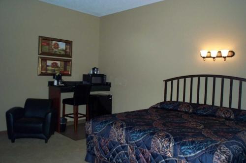 a bedroom with a bed and a chair and a desk at Americas Best Value Inn Big Lake Becker in Big Lake