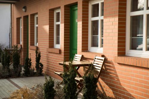 two chairs and a table in front of a brick building at Mistral Ustka in Ustka