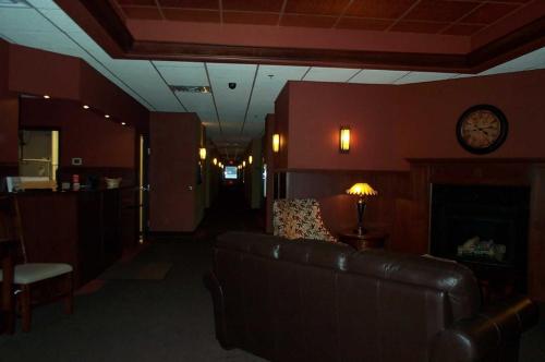 a living room with a couch and a clock on the wall at Americas Best Value Inn Big Lake Becker in Big Lake