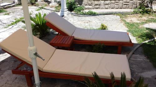 two chairs and an umbrella on a patio at Kazablanka Rooms Aerodrom in Podgorica