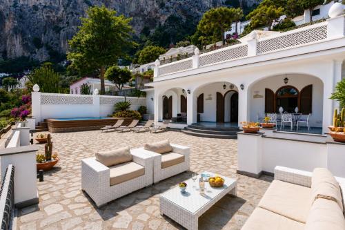 Villa Capri by MyVillaCollection في كابري: فناء خارجي مزود بأرائك وطاولات في منزل