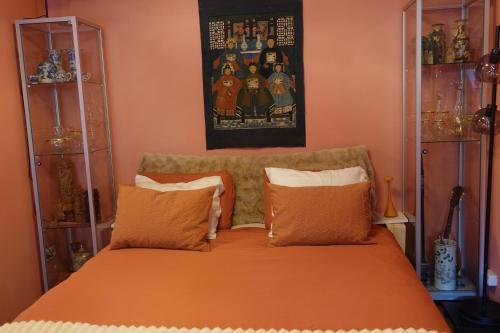 a bedroom with a bed with an orange bedspread at Exceptional B&B in Reeuwijk