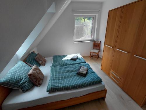 a bed with green sheets and pillows in a room at Alte Mühle in Holzminden