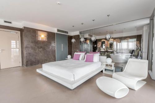 a bedroom with a large white bed and a bathroom at Hotel For You in Cernusco sul Naviglio