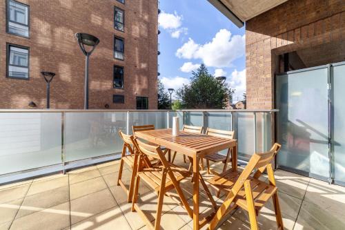a wooden table and chairs on a balcony at Gorgeous 1 Bed Apartment in Poplar in Richmond upon Thames