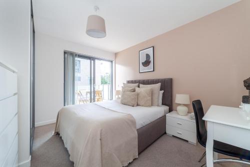 a white bedroom with a bed and a window at Gorgeous 1 Bed Apartment in Poplar in Richmond upon Thames