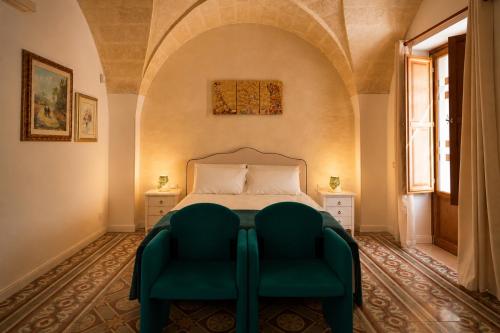 a bedroom with a bed and a green chair at Residenza Kalù in Grottaglie