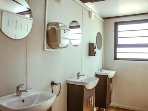 a bathroom with two sinks and two mirrors at Karoo 62 Bush Motel in Ladismith