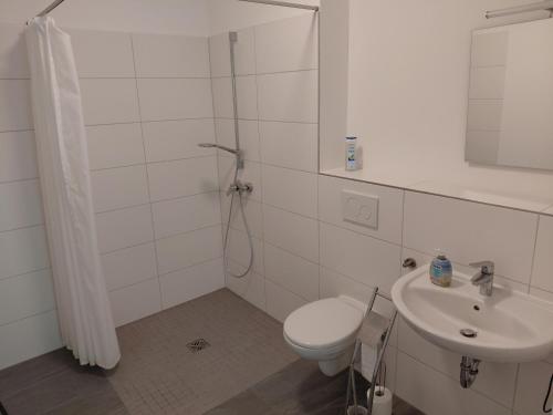 a white bathroom with a toilet and a sink at Alte Mühle in Holzminden
