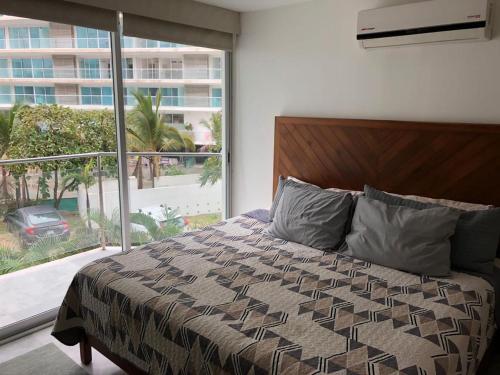 a bedroom with a bed and a large window at Aria Ocean Rentals - Riviera Nayarit in Nuevo Vallarta