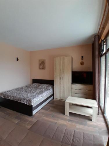 a bedroom with a bed and a bench in it at Tara Organic in Zaovine