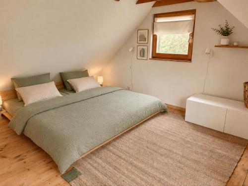 a bedroom with a large bed and a window at Cottage by the Jizera river in Nový Vestec