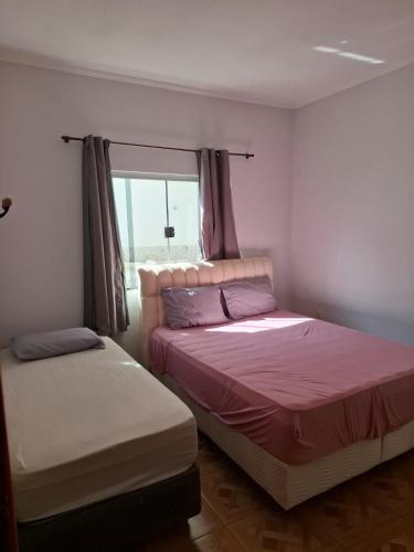 a bedroom with two beds and a window at casa da Roberta SJB capitólio in São José da Barra