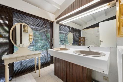 a bathroom with two sinks and a large window at Maison de vacances Namasté in Mérignac