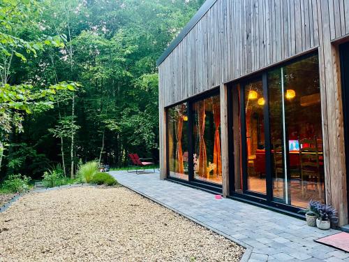 a building with glass windows and a patio at La Noisette in Florennes