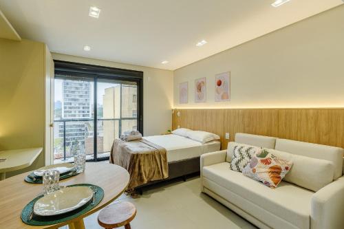 a hotel room with a bed and a couch at Soul República - Cidade Baixa in Porto Alegre