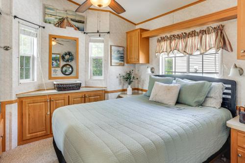 a bedroom with a bed and a sink and windows at Pool + Dock Access! Boater’s Base in Lake Placid in Lake Placid