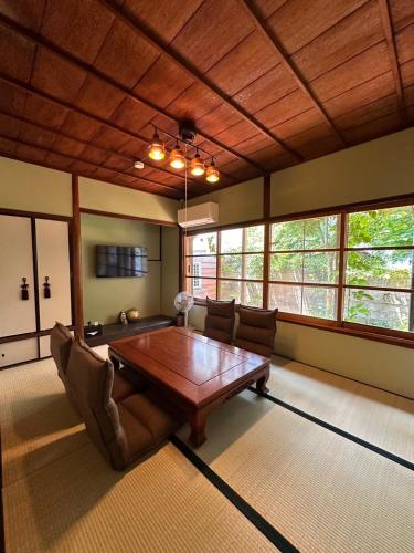 a dining room with a wooden table and chairs at Kanazawa Machiya Kasaichi - Entire House Free Parking in Kanazawa