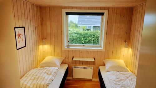 a small room with two beds and a window at Holiday Home Als - Starfish in Nordborg