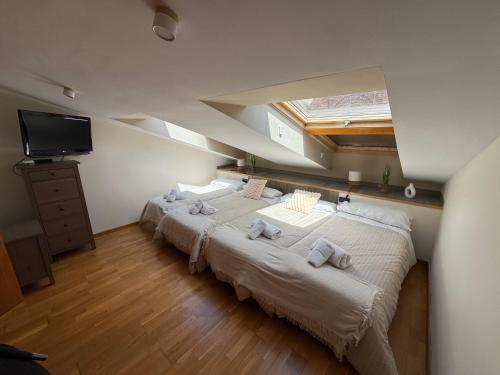 a bedroom with two beds with towels on them at Duplex Amantes in Teruel