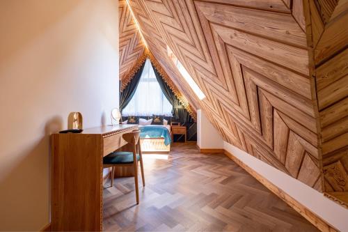 a room with a wooden wall with a desk and a window at Tatra Forest Apartments in Zakopane