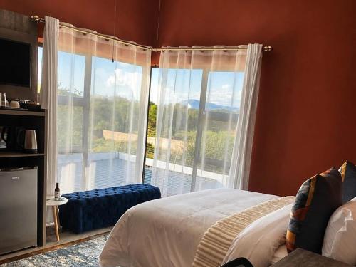 ein Schlafzimmer mit einem Bett und einem großen Fenster in der Unterkunft Gee Heights Private Boutique Guest House in Thabazimbi