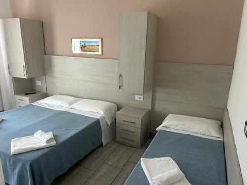 a small bedroom with two beds and a cabinet at Residence Abamar in Rimini