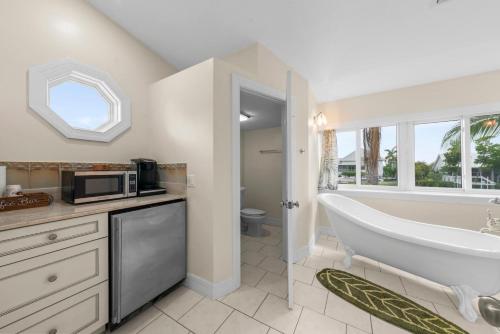 a bathroom with a tub and a sink and a microwave at Salt Life Sanctuary in Sanibel
