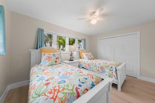 a bedroom with two beds and a ceiling fan at Salt Life Sanctuary in Sanibel