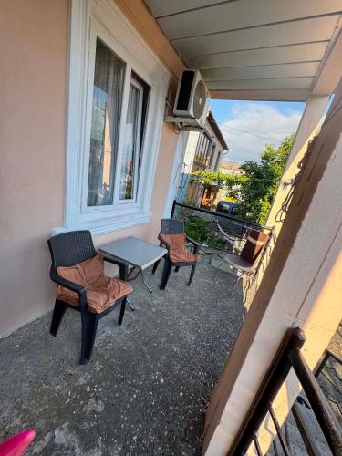 a patio with two chairs and a table on a balcony at Cozy-home in Kobuleti