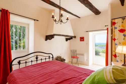 a bedroom with a red bed and a window at Chez Bacchus - Chambres in Gras