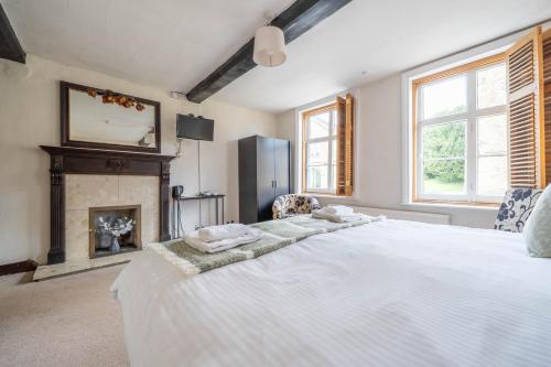 a bedroom with a large white bed and a fireplace at Kings Arms Hotel in Cleobury Mortimer