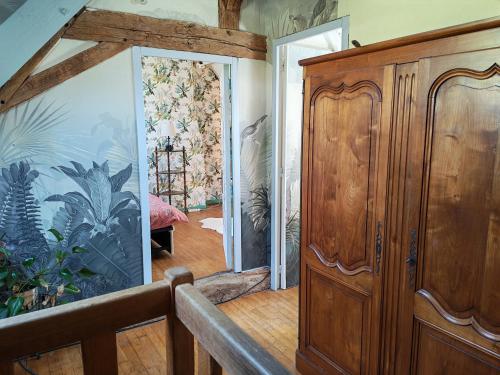 a room with a wooden cabinet and a glass wall at Une chambre en Amazonie in Le Menoux