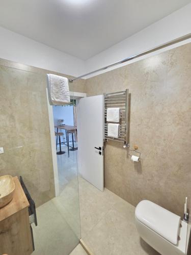 ein Badezimmer mit Toilette, Waschbecken und Tisch in der Unterkunft Chic Studio in Bukarest