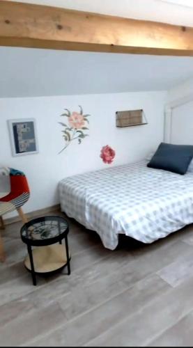 a bedroom with a bed and a table at La Garrigue in Calvisson