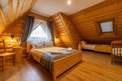 a bedroom with a bed in a log cabin at Apartamenty pod Góralskim Niebem in Gliczarów Górny