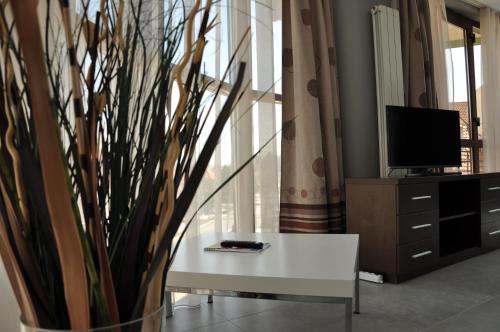 a living room with a white table and a tv at Yes Home in Călimăneşti
