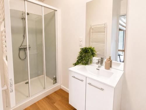 a white bathroom with a shower and a sink at Studio cosy avec terrasse - Proche château in Fougères
