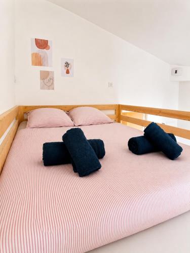 a bed with pink and blue pillows on it at Studio cosy avec terrasse - Proche château in Fougères