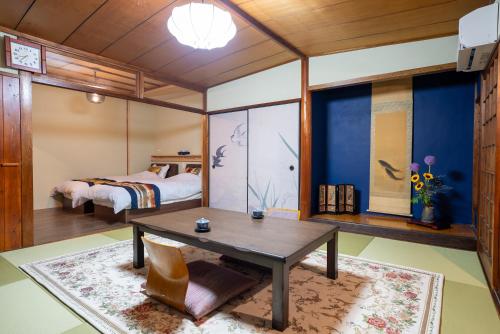 a bedroom with a bed and a table in a room at 尾道つばめ堂 Onomichi Tsubamedo in Onomichi