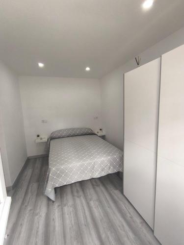 a bedroom with a bed and white walls at Casa La Cordelera in Salinas